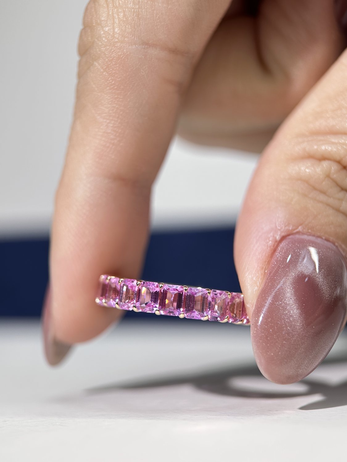 Rainbow sapphire tennis bracelet held in hand